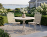 Woodard Briarwood dining chairs at the 48" mesh top round table on a seaside patio