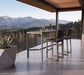 Woodard Harper bar stools at the Profile sintered stone bar table on a mountain-view terrace