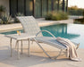 Woodard Thatch top square side table beside a sling chaise by a pool