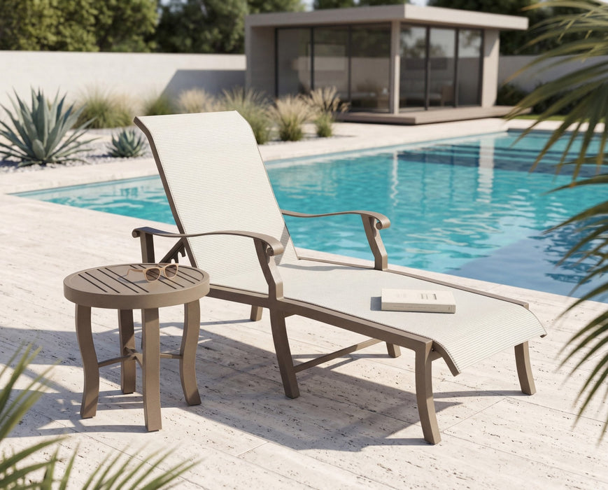 Tri-Slat Carson round side table beside a sling chaise by a pool