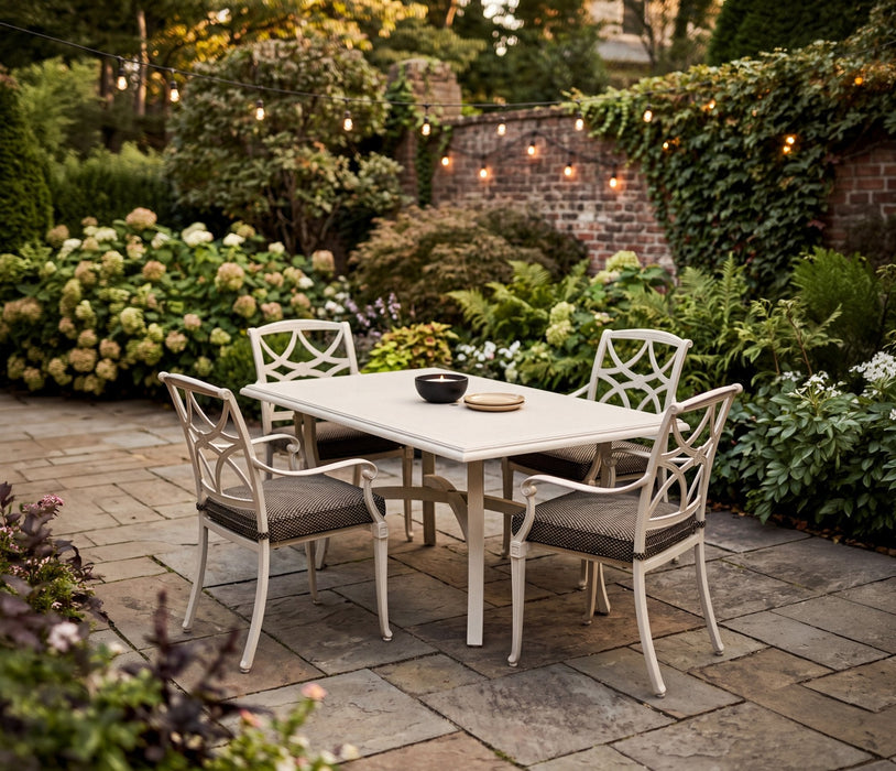 Woodard Wiltshire dining arm chairs with seat cushions around a table on a garden patio