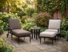 Woodard Wiltshire adjustable chaise lounge and a lounge chair with ottoman in a courtyard garden